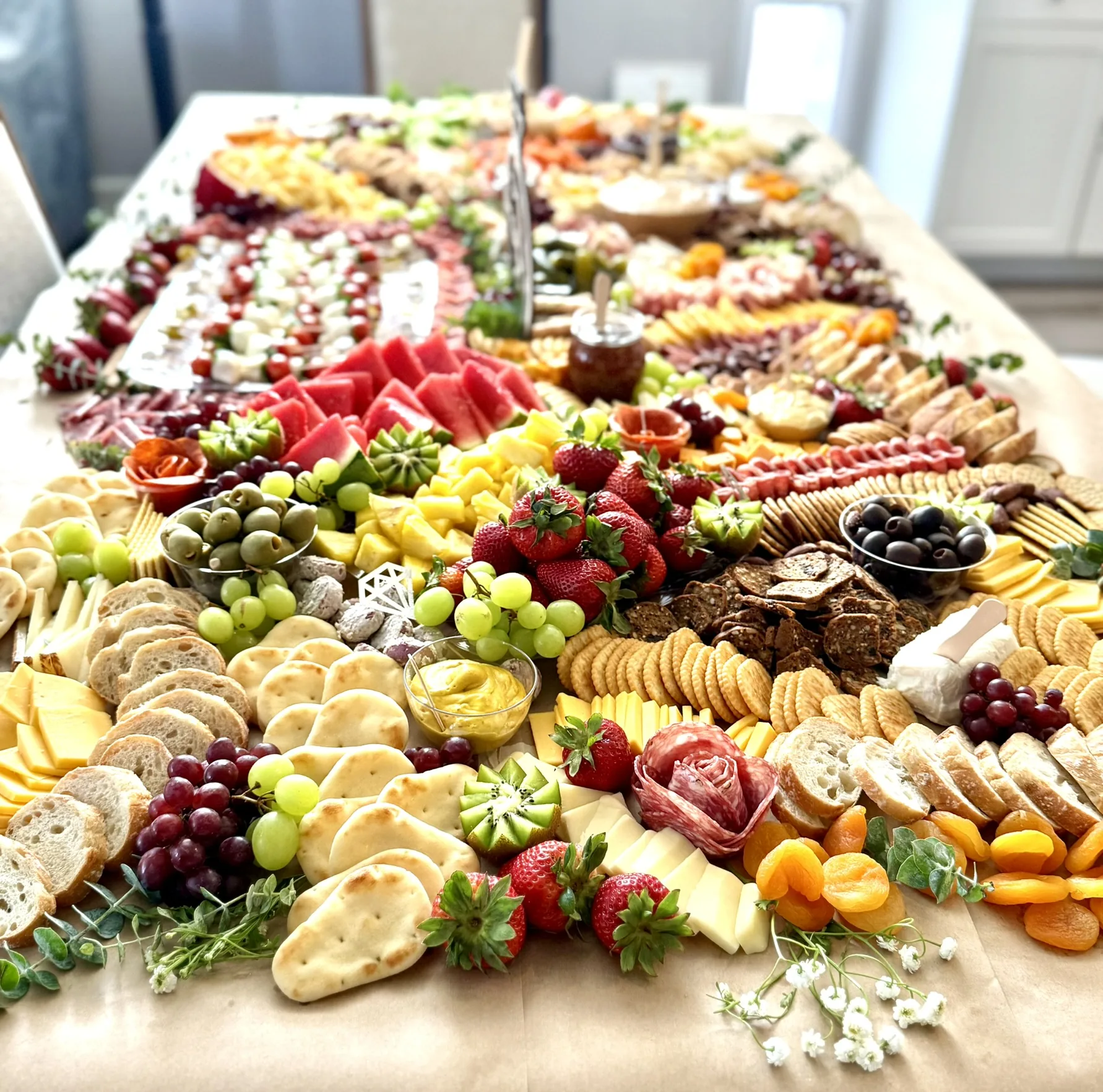 A long grazing table covered in charcuterie
